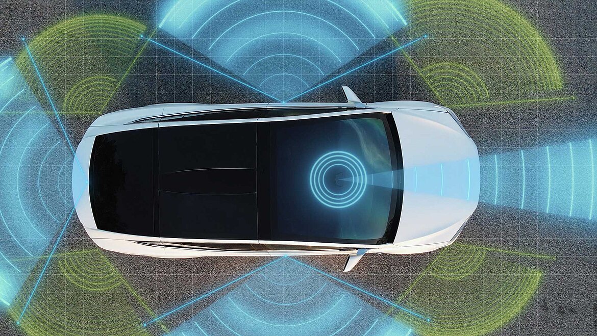 Vista superior de un coche con campos de sensores coloridos para detectar entorno y distancia